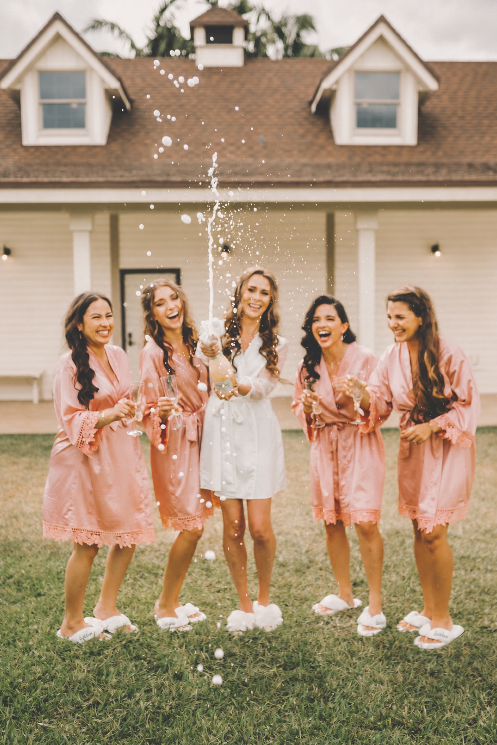A bride and her bridal party celebrating with champagne on the private estate grounds